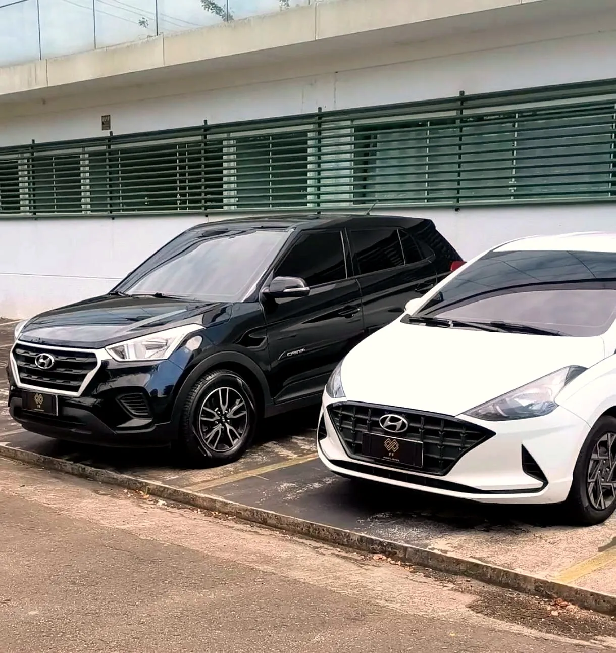 Os carros da FF Mobilidade: SUV preto e sedan branco, limpos e conservados, com o brasão FF