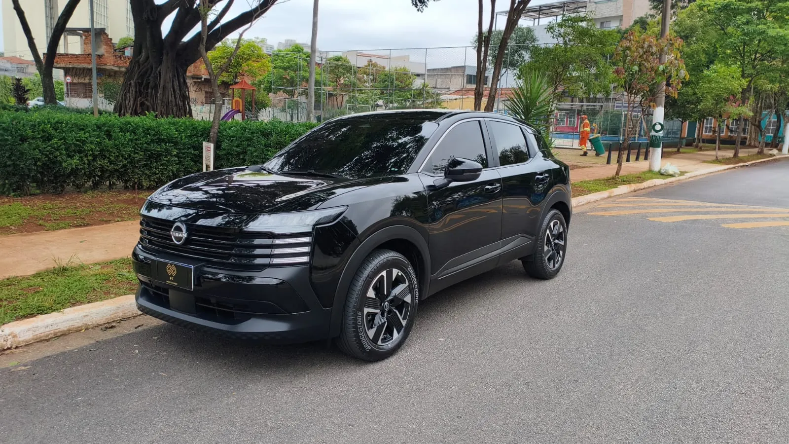 Nissan Kicks preto da FF Mobilidade, visto de frente em tr&ecirc;s quartos, estacionado em rua arborizada de S&atilde;o Paulo